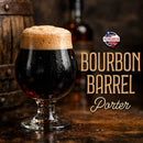 Glass of Bourbon Barrel Porter with a barrel and bottle in the background.