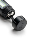 Close-up of the Milwaukee pH54 battery compartment with cap removed, showing the battery contacts and pull tab for easy battery replacement.