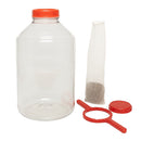 6-gallon clear FerMonster fermenter with red lid shown alongside included accessories — mesh straining bag, red lid wrench, and solid replacement lid — displayed on a clean white background.