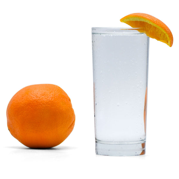 A glass of Navel Orange Hard Seltzer with an orange wedge.