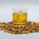 Wheated Bourbon Whiskey in a glass with ice with oak chips around it.