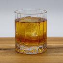 High Rye Bourbon Whiskey in a glass with ice on a wood table.