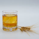 Single malt whiskey in  glass with barely next to it.