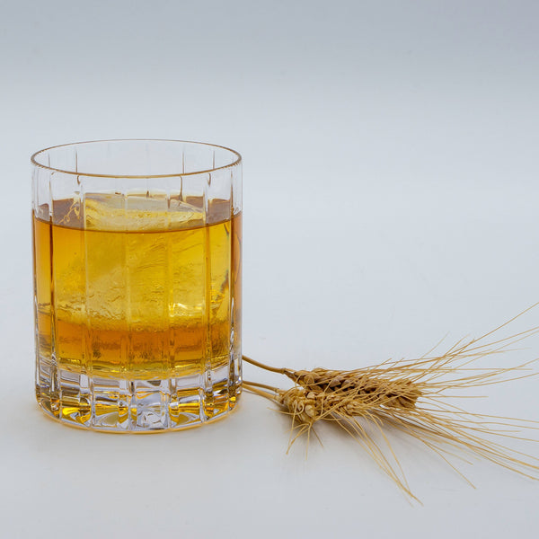 Single malt whiskey in  glass with barely next to it.