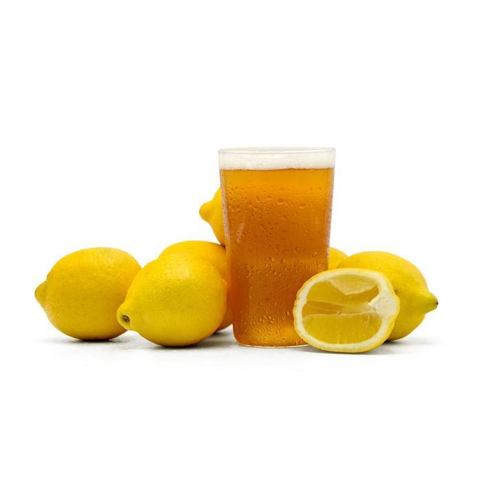 Summer Squeeze Lemon Shandy in a glass surrounded by cut lemons