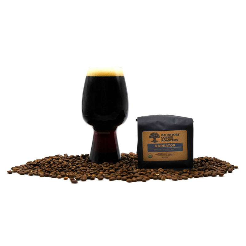 Blue Collar Coffee Stout surrounded by coffee beans and a bag of backstory coffee